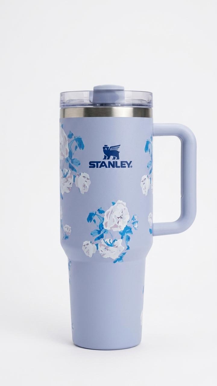 Blue Stanley tumbler with floral design on a white background